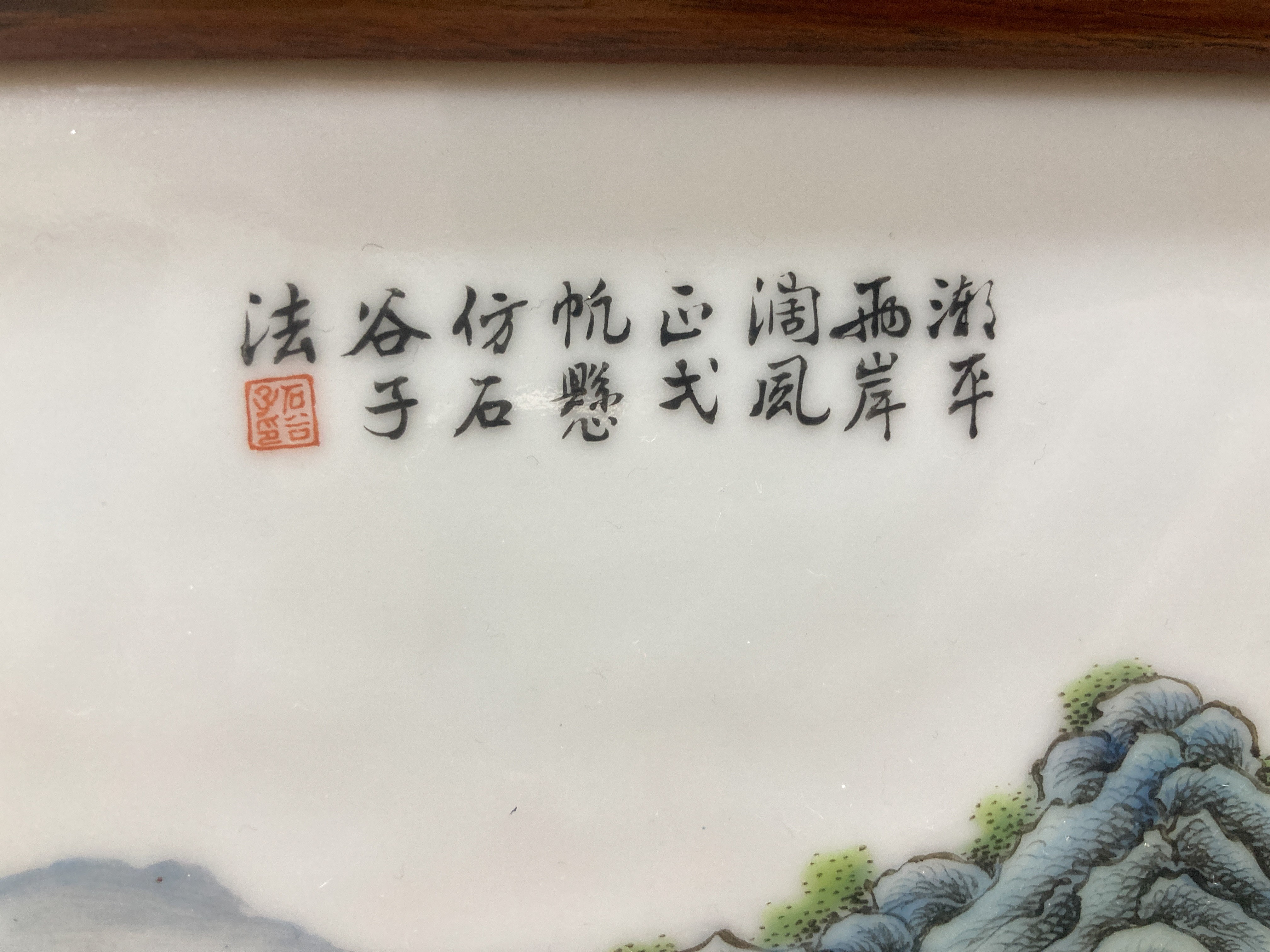 A 20th century Republic period porcelain plaque decorated in coloured enamels with landscape scene, inscription mark 24 x 38cm in carved frame